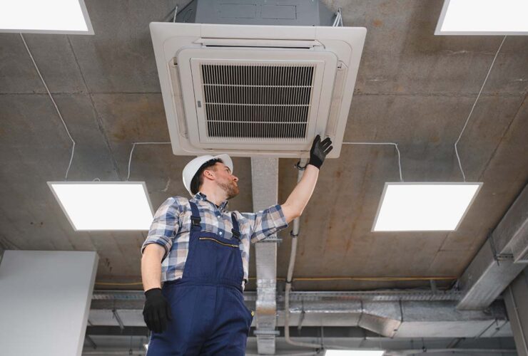 operaio che installa un impianto di condizionamento in un ufficio