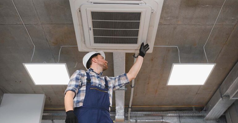operaio che installa un impianto di condizionamento in un ufficio